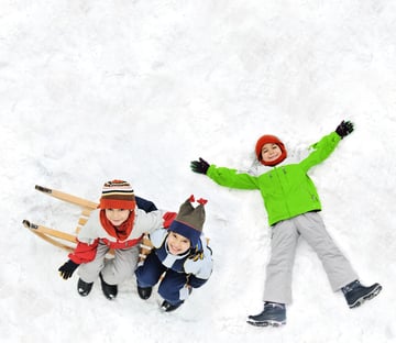 Happy kids with sledding on snow ground